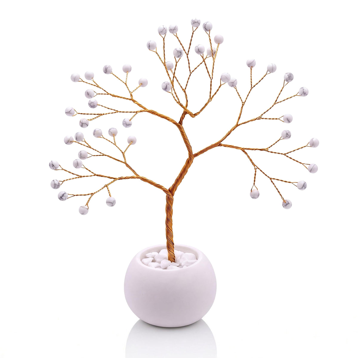 Gold-plated wire tree with polished white howlite beads with grey veining in a white bowl with white pebbles
