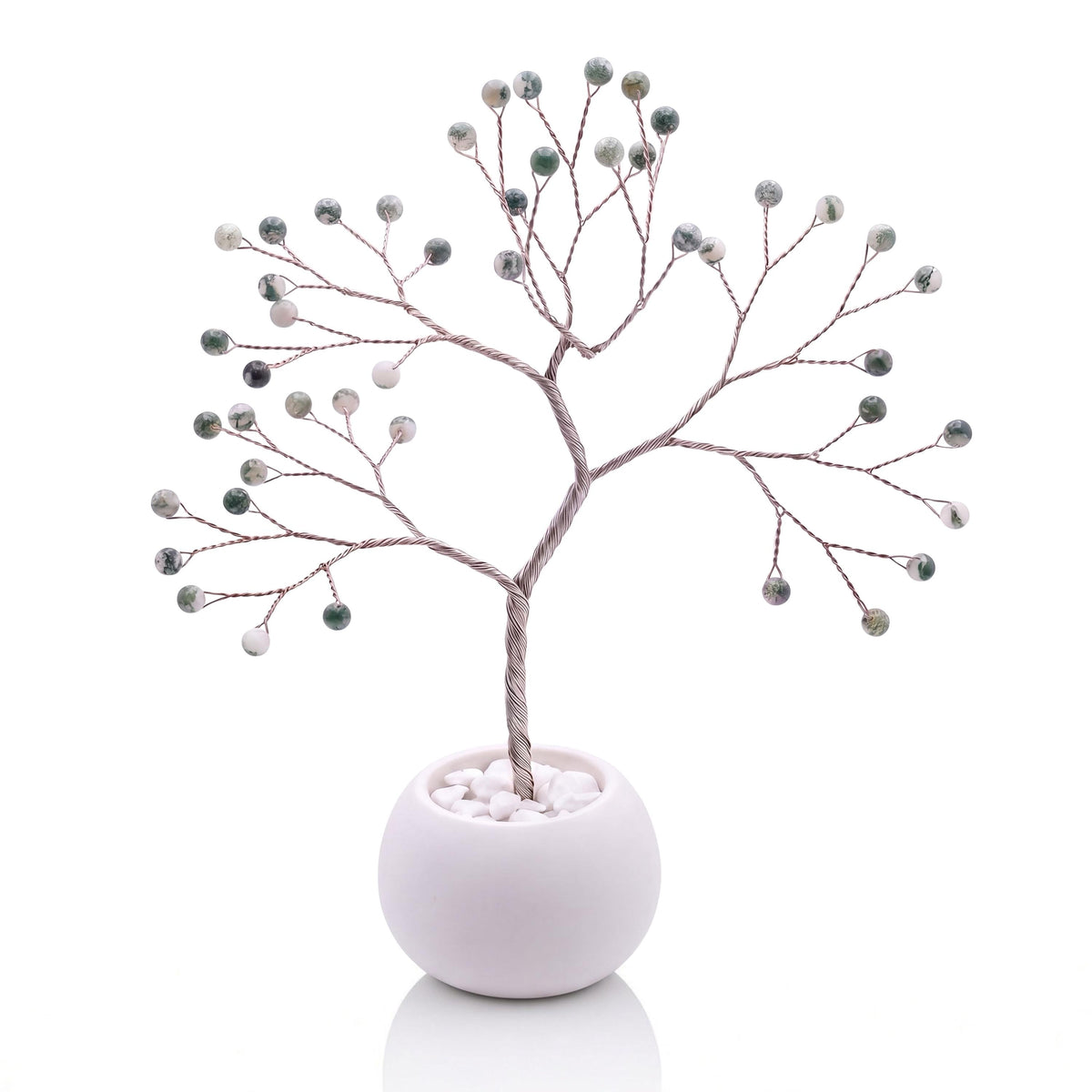 Silver-plated wire tree with polished snowy white and fir green tree agate beads in a white bowl with white pebbles