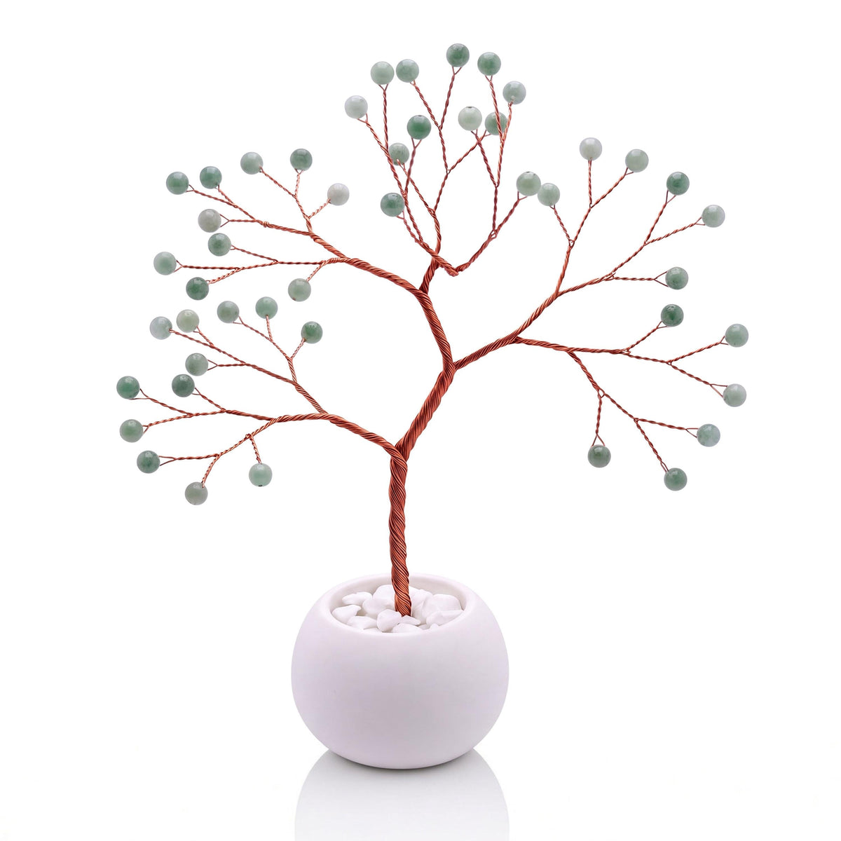 Copper wire tree with polished spring leaf green jadeite beads in a plain white bowl filled with white pebbles