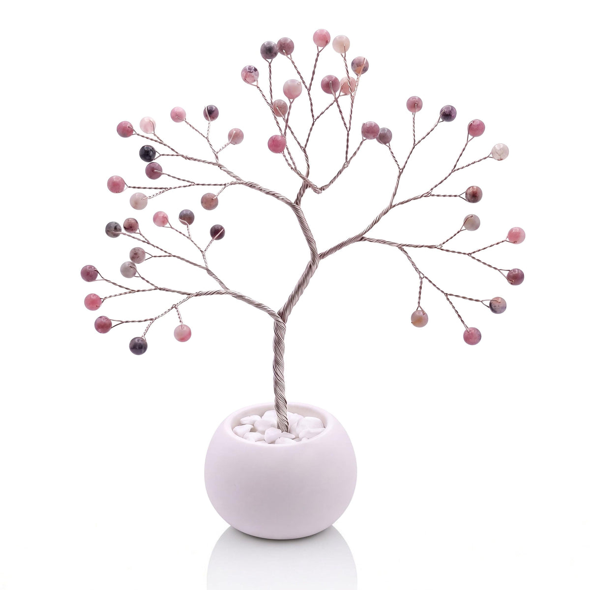 Silver-plated wire tree with polished lingonberry pink thulite beads in a white bowl with white pebbles