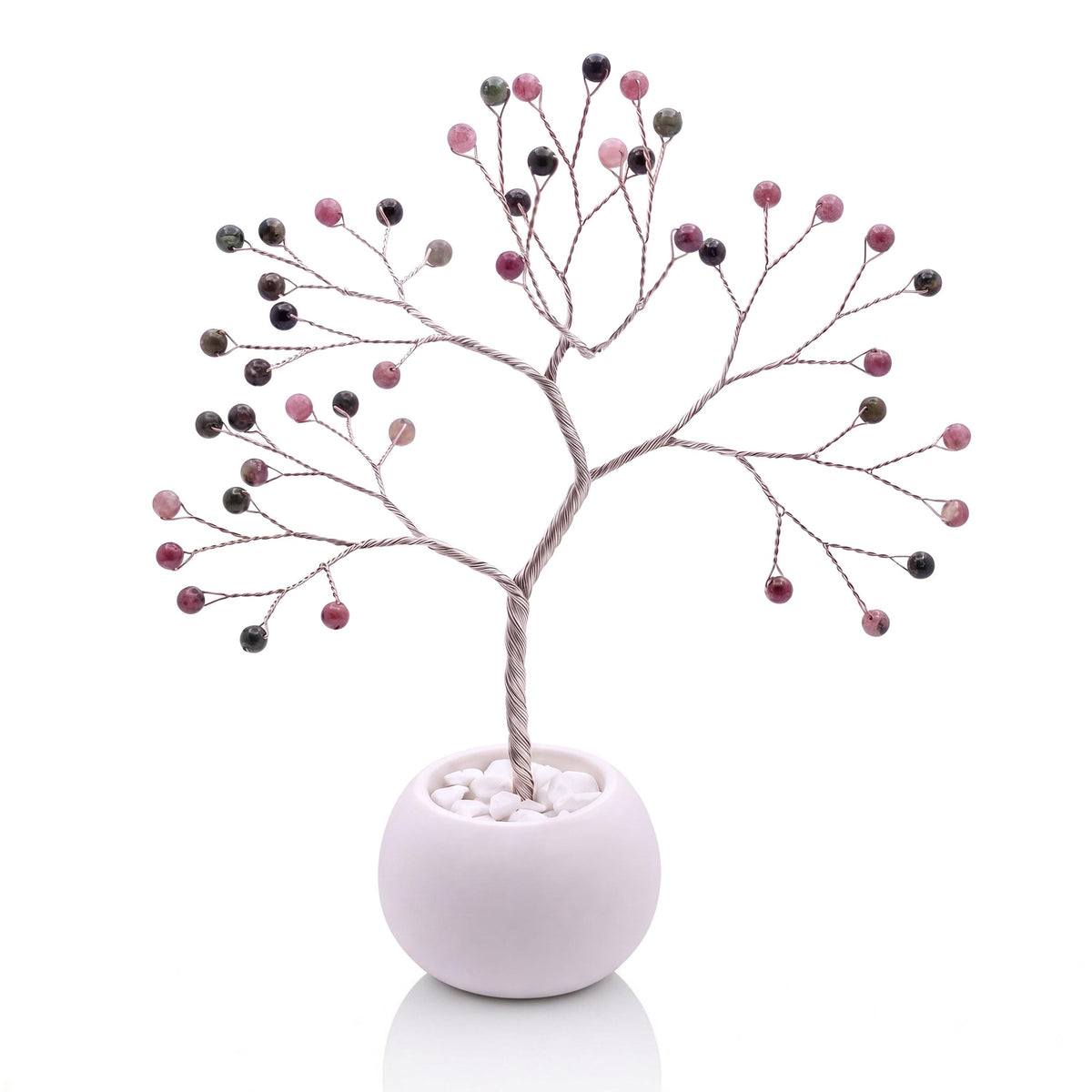 Silver-plated wire tree with polished rhubarb pink and sage green tourmaline beads in a white bowl with white pebbles
