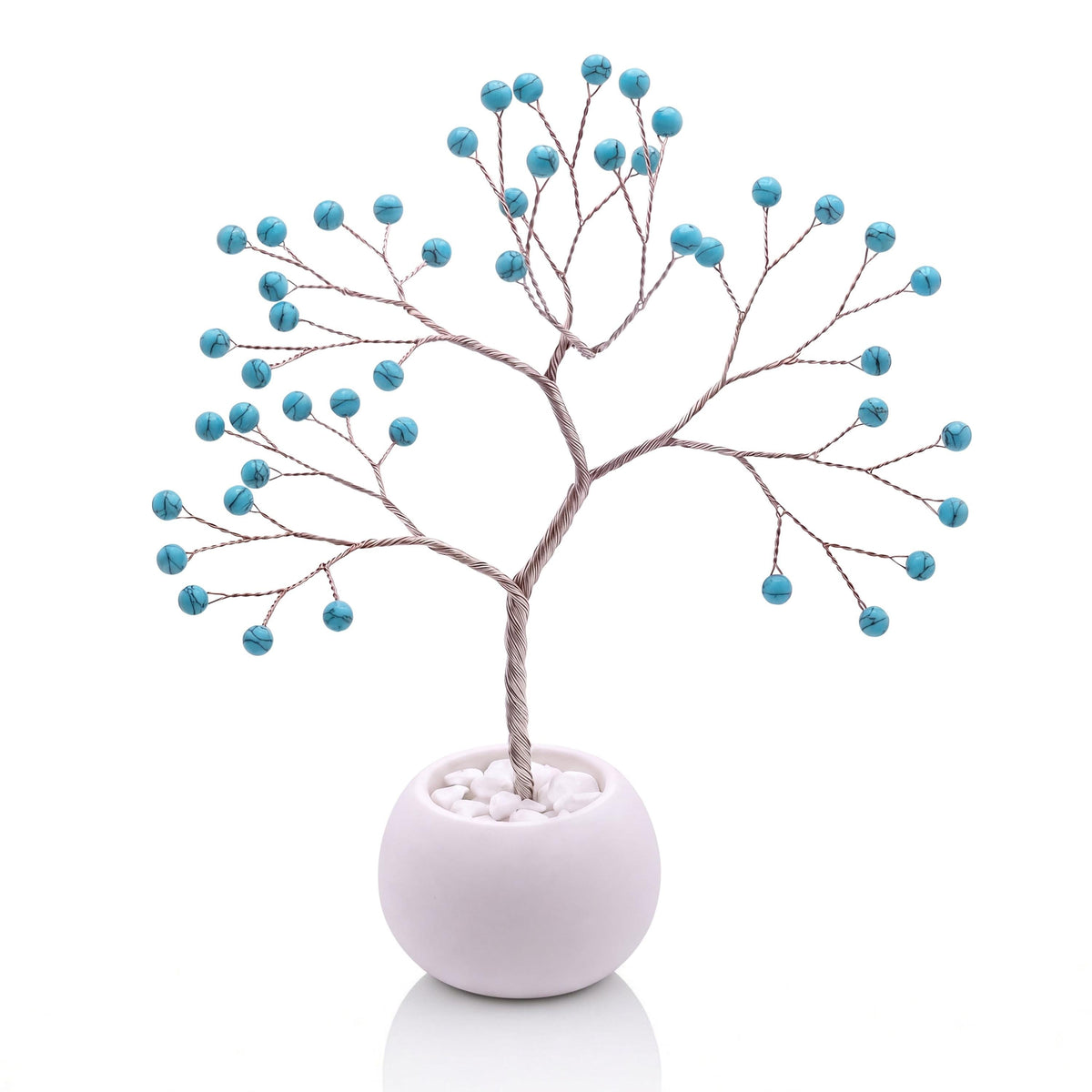 Silver-plated wire tree with polished robin's egg blue howlite beads in a white bowl with white pebbles