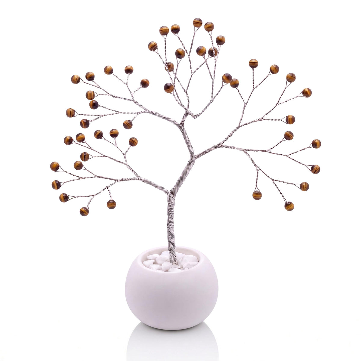 Silver-plated wire tree with polished golden brown tiger's eye beads in a white bowl with white pebbles