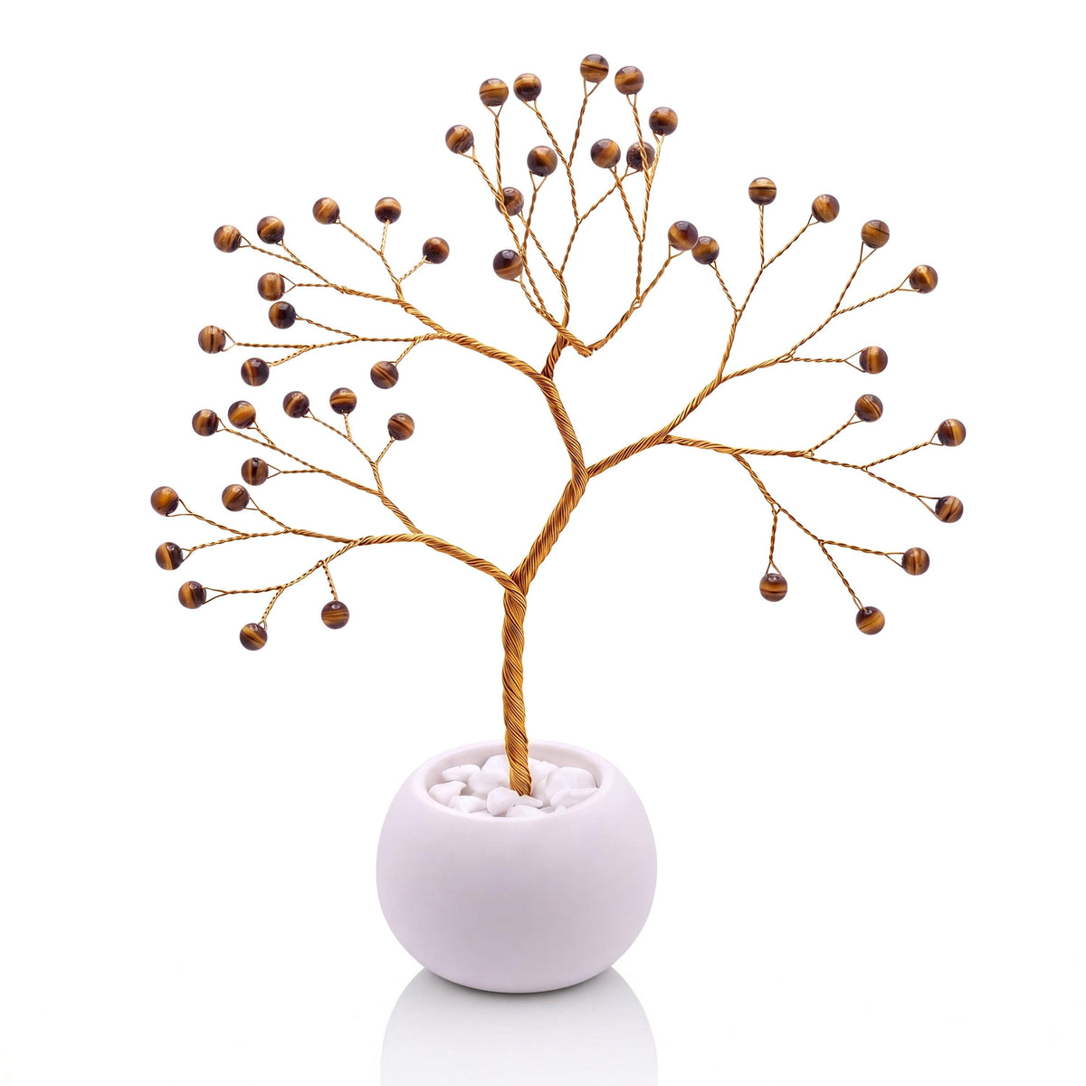 Gold-plated wire tree with polished golden brown tiger's eye beads in a white bowl with white pebbles