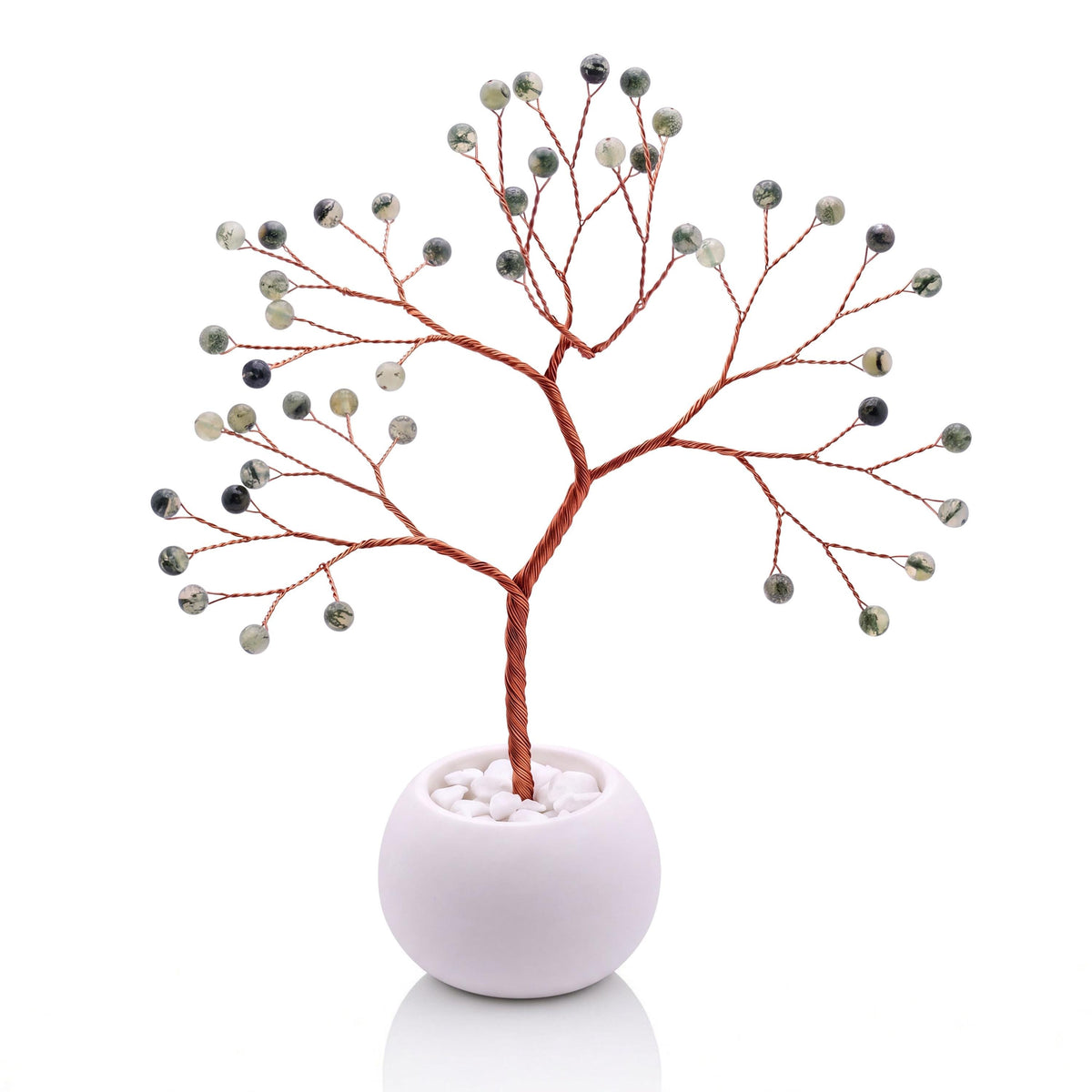 Copper wire tree with polished green prehnite beads in a plain white bowl filled with white pebbles