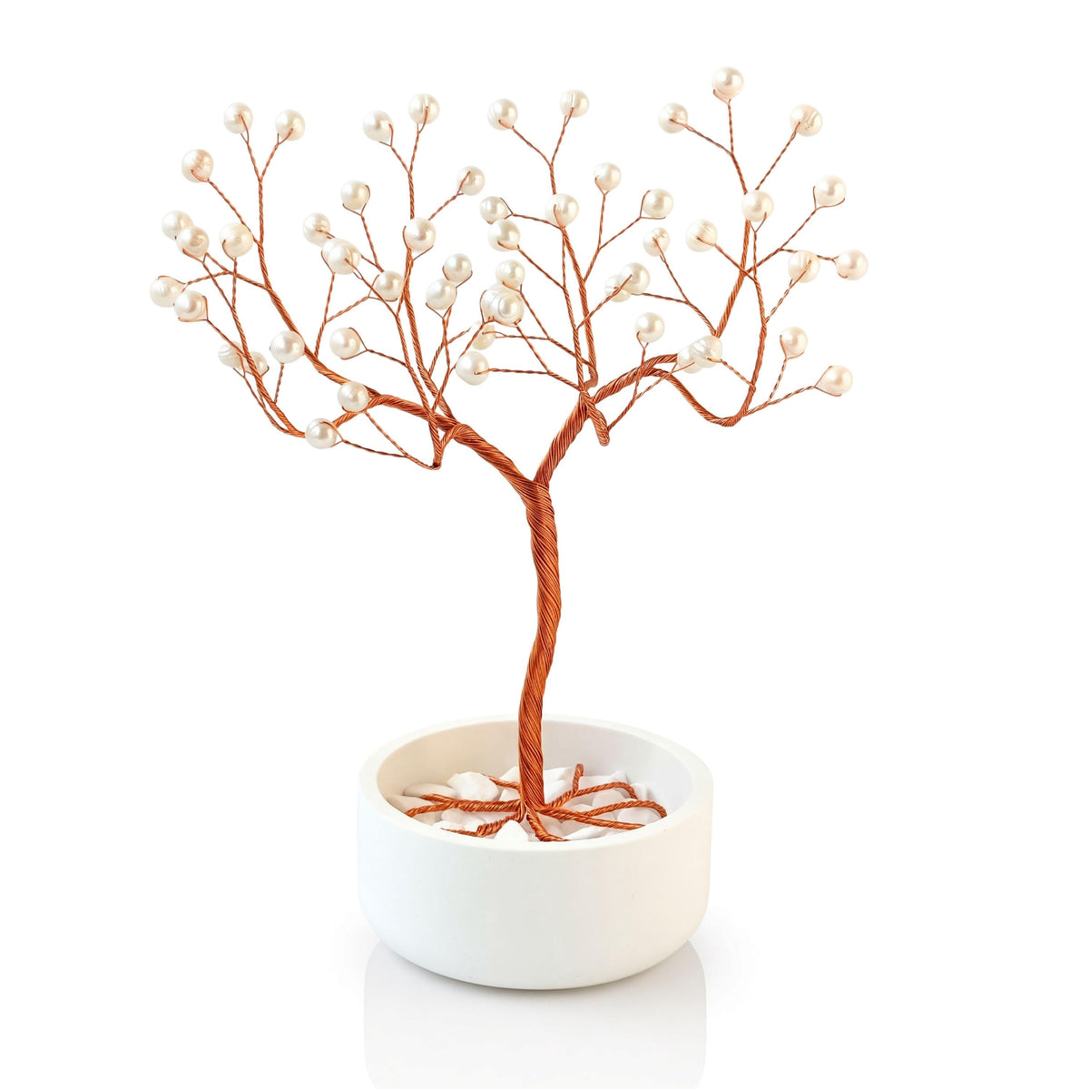 Handmade copper wire tree with white freshwater pearls in a plain white ceramic bowl