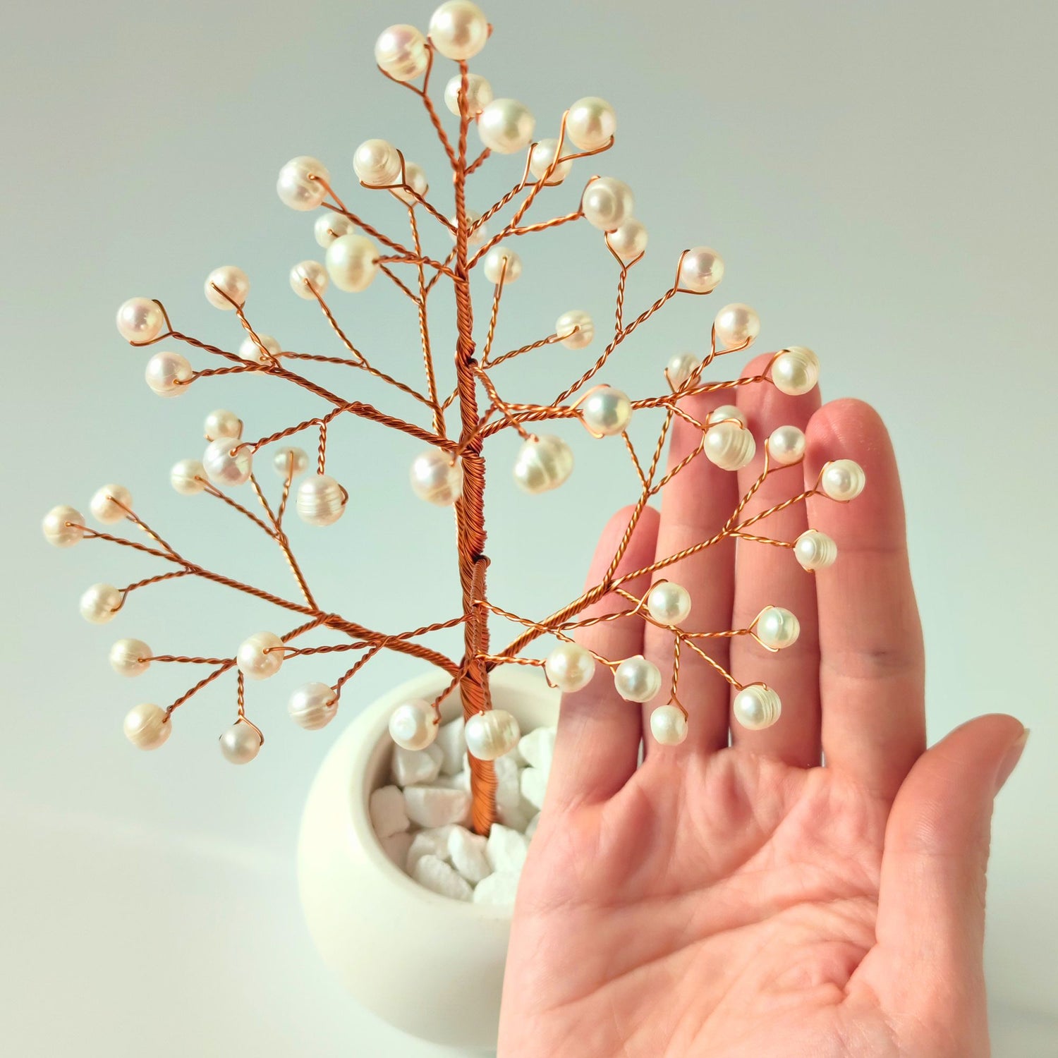 Close-up of Pearl Christmas Tree branch held in hand showing natural freshwater pearls