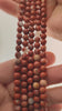Video of strands of canyon red jasper beads with white veins used for this tree, held in the hand