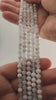 Video of strands of milky white dendritic opal spheres used for this tree, held in the hand