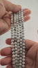 Video of strands of white howlite beads with grey veining used for this tree, held in the hand