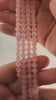 Video of strands of pale pink rose quartz spheres used for this tree, held in the hand