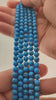 Video of strands of turquoise blue howlite spheres used for this tree, held in the hand