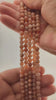 Video of strands of tangerine orange moonstone beads used for this tree, held in the hand