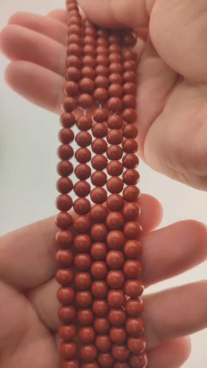 Video of strands of brick red jasper beads used for this tree, held in the hand