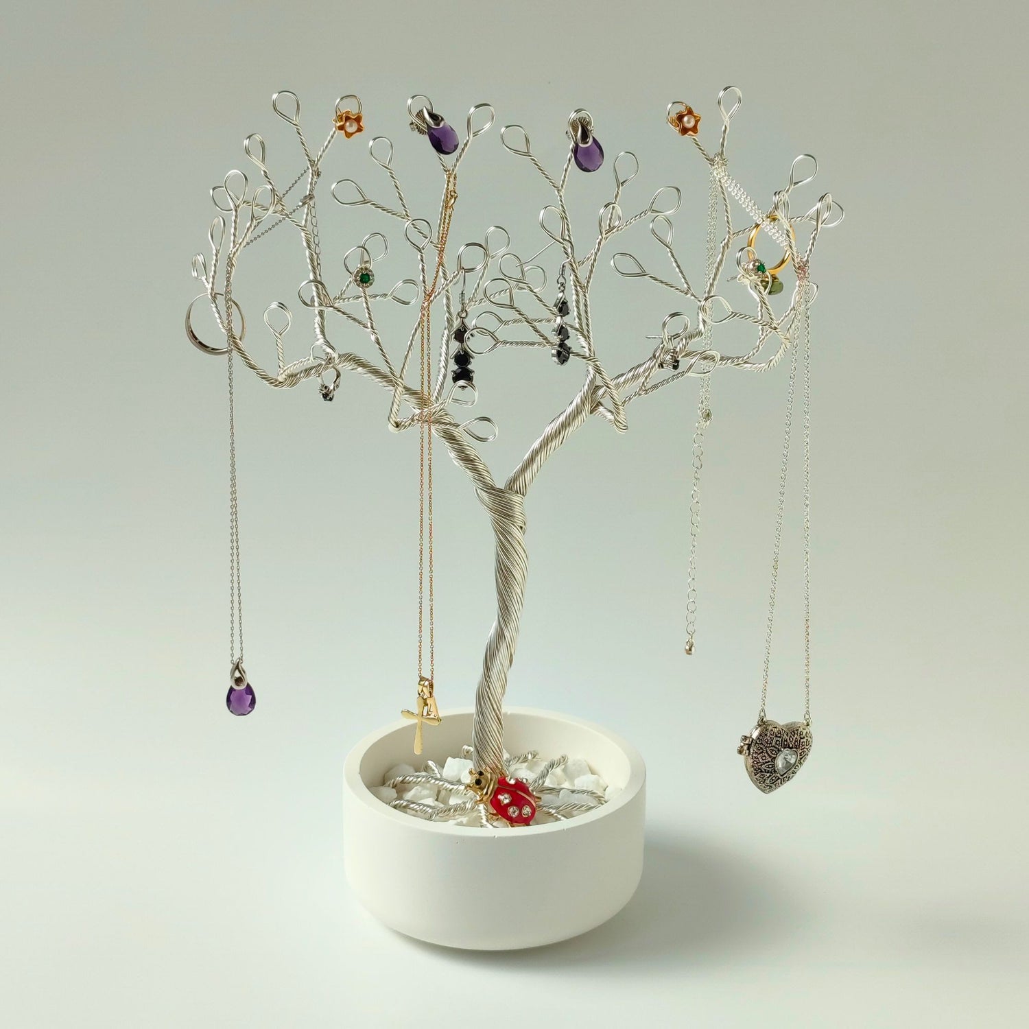 Jewelry tree made of silver plated wire in bowl with white stones